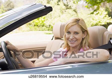 Woman in convertible car smiling View Large Photo Image Picture - Woman in convertible car smiling. Fotosearch