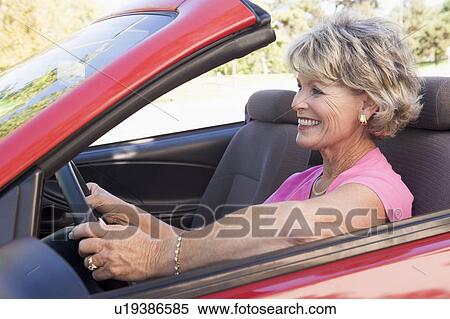 Stock Photography - Woman in convertible car smiling. Fotosearch