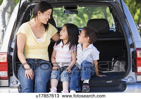 Woman with two children sitting in back of van smiling View Large Photo Image Stock Image - Woman with two children sitting in back of van smiling. Fotosearch