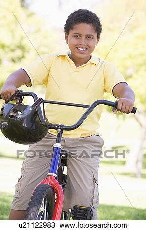 Young boy on bicycle outdoors smiling View Large Photo Image Stock Image - Young boy on bicycle outdoors smiling. Fotosearch