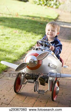 Stock Image - Young boy playing outdoors in airplane smiling. Fotosearch