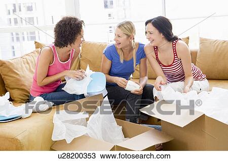 Three girl friends unpacking boxes in new home smiling View Large Photo Image Stock Image - Three girl friends unpacking boxes in new home smiling. Fotosearch