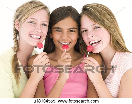Stock Photography - Three girl friends with suckers smiling. Fotosearch