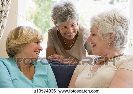 Three women in living room talking and smiling View Large Photo Image Stock Photograph - Three women in living room talking and smiling. Fotosearch