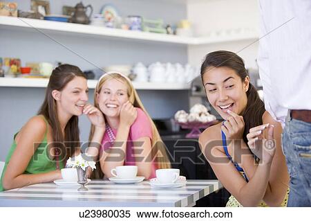 Stock Photography - Three young women eyeing the backside of a man. Fotosearch