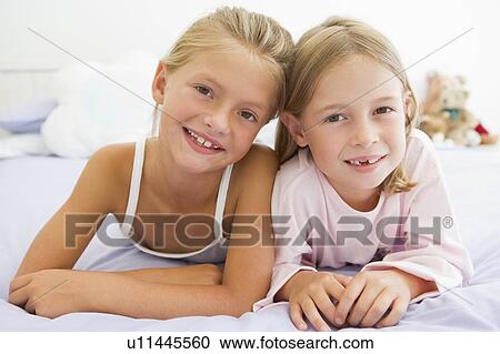 Two Young Girls In Their Pajamas Lying On A Bed View Large Photo Image Stock Image - Two Young Girls In Their Pajamas Lying On A Bed. Fotosearch