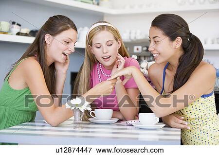Young woman showing off engagement ring to friends View Large Photo Image Stock Photo - Young woman showing off engagement ring to friends. Fotosearch
