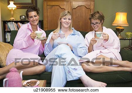 Young woman sitting on sofa at home drinking tea View Large Photo Image Stock Photography - Young woman sitting on sofa at home drinking tea. Fotosearch