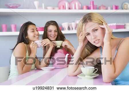 Young woman with a hangover sitting at a table with two friends View Large Photo Image Stock Image - Young woman with a hangover sitting at a table with two friends. Fotosearch