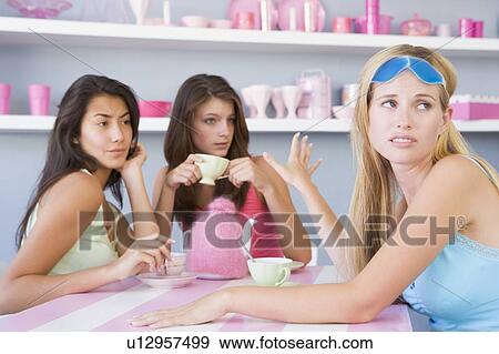 Young woman with a hangover sitting at a table with two friends View Large Photo Image Stock Photo - Young woman with a hangover sitting at a table with two friends. Fotosearch