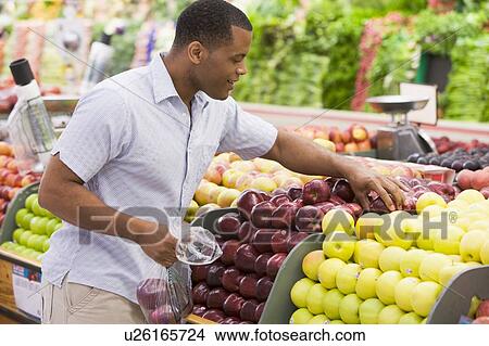 Man shopping for apples at a grocery store View Large Photo Image Picture - Man shopping for apples at a grocery store. Fotosearch
