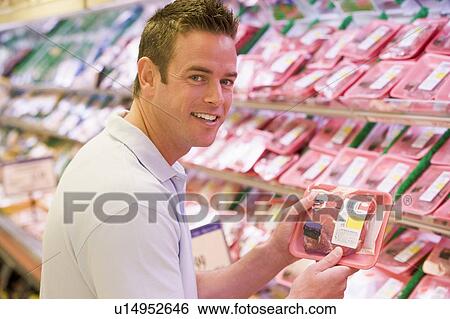 Man shopping for meat at a grocery store View Large Photo Image Stock Photograph - Man shopping for meat at a grocery store. Fotosearch