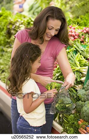 Mother and daughter shopping for broccoli at a grocery store View Large Photo Image Stock Image - Mother and daughter shopping for broccoli at a grocery store. Fotosearch