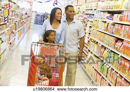 Mother and father with young daughter shopping at the grocery store. View Large Photo Image Picture - Mother and father with young daughter shopping at the grocery store.. Fotosearch