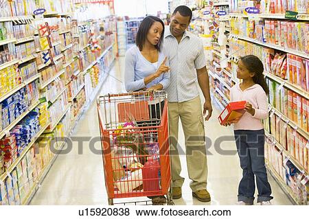 Stock Photo - Mother and father with young daughter shopping at the grocery store.. Fotosearch