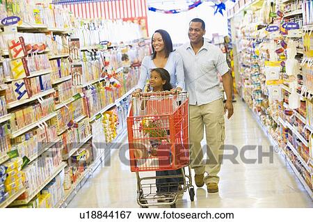 Stock Photo - Mother and father with young daughter shopping at the grocery store.. Fotosearch