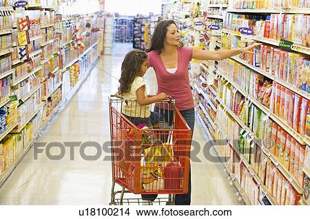 Mother and young daughter shopping at a grocery store View Large Photo Image Picture - Mother and young daughter shopping at a grocery store. Fotosearch