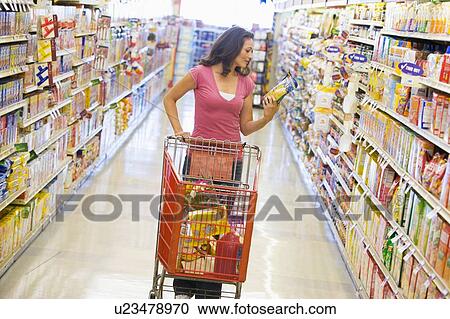 Stock Image - Woman shopping at a grocery store. Fotosearch