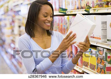Woman shopping at a grocery store View Large Photo Image Stock Photograph - Woman shopping at a grocery store. Fotosearch