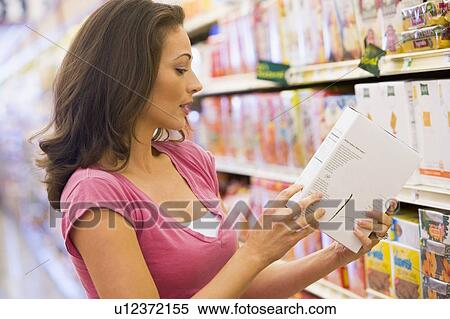 Stock Photography - Woman shopping at a grocery store. Fotosearch