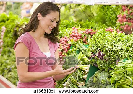 Woman shopping for broccoli at a grocery store View Large Photo Image Stock Image - Woman shopping for broccoli at a grocery store. Fotosearch