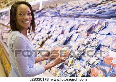 Woman shopping for fish and seafood at a grocery store View Large Photo Image Stock Photo - Woman shopping for fish and seafood at a grocery store. Fotosearch
