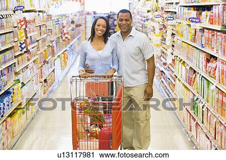 Stock Image - Young couple shopping at a grocery store. Fotosearch