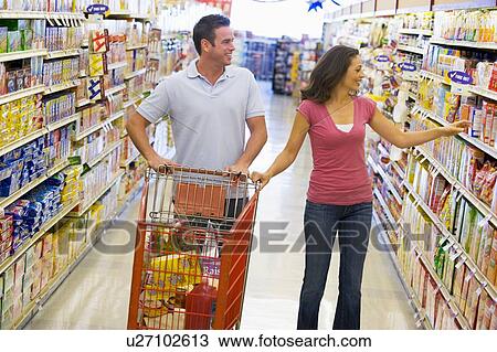 Stock Image - Young couple shopping at a grocery store. Fotosearch