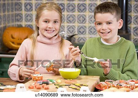 Brother and sister at Halloween making treats and smiling View Large Photo Image Stock Photo - Brother and sister at Halloween making treats and smiling. Fotosearch