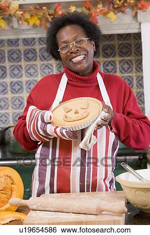 Woman in kitchen making Halloween treats and smiling View Large Photo Image Stock Photograph - Woman in kitchen making Halloween treats and smiling. Fotosearch