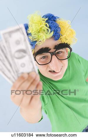 Young boy wearing clown wig and fake nose holding money View Large Photo Image Picture - Young boy wearing clown wig and fake nose holding money. Fotosearch
