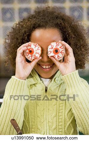 Young girl at Halloween playing with treats and smiling View Large Photo Image Stock Image - Young girl at Halloween playing with treats and smiling. Fotosearch