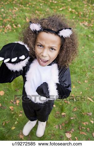 Stock Photography - Young girl outdoors in cat costume on Halloween. Fotosearch