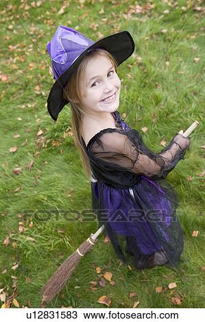 Stock Image - Young girl outdoors in witch costume on Halloween. Fotosearch