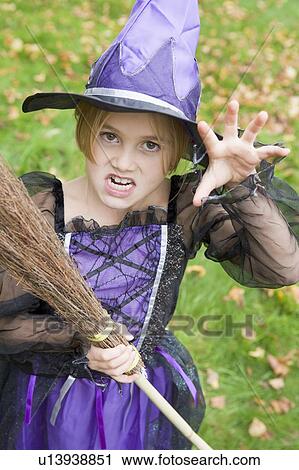 Stock Image - Young girl outdoors in witch costume on Halloween. Fotosearch
