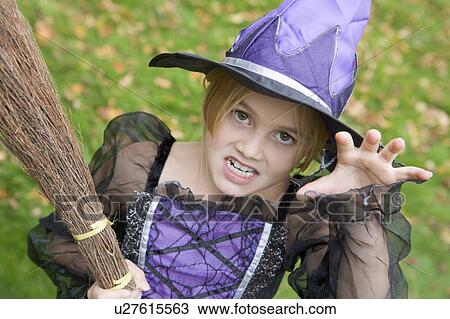 Stock Image - Young girl outdoors in witch costume on Halloween. Fotosearch