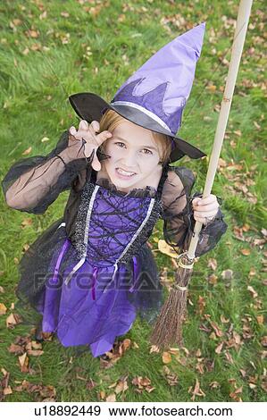 Stock Photo - Young girl outdoors in witch costume on Halloween. Fotosearch