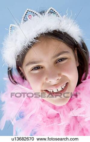 Stock Image - Young girl wearing crown and feather boa smiling. Fotosearch