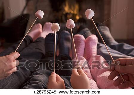 Feet warming at a fireplace with marshmallows on sticks View Large Photo Image Stock Photography - Feet warming at a fireplace with marshmallows on sticks. Fotosearch