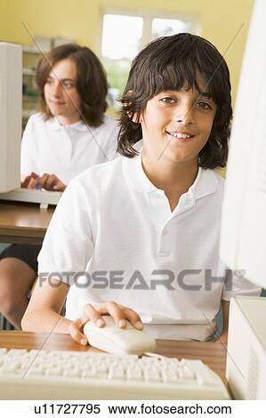 Student at computer terminal with student in background (selective focus) View Large Photo Image Stock Photography - Student at computer terminal with student in background (selective focus). Fotosearch