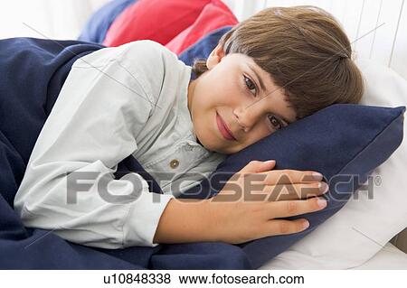 Stock Photo - Young Boy Lying Down In His Bed. Fotosearch