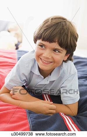 Stock Photo - Young Boy Lying Down On His Bed. Fotosearch