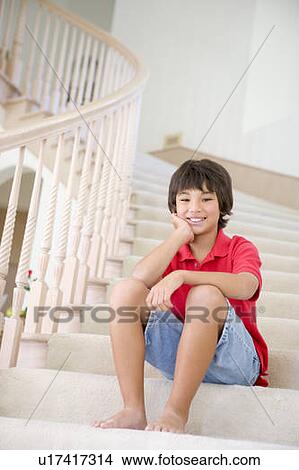 Picture - Young Boy Sitting On A Stairwell At Home. Fotosearch