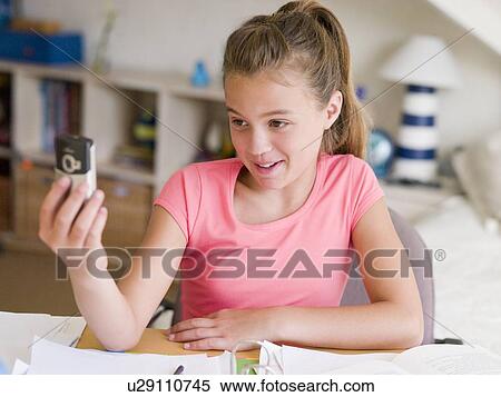 Young Girl Distracted From Her Homework, Playing With A Cellphone View Large Photo Image Stock Photography - Young Girl Distracted From Her Homework, Playing With A Cellphone. Fotosearch