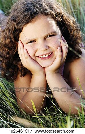 Young girl lying outdoors smiling View Large Photo Image Stock Photo - Young girl lying outdoors smiling. Fotosearch