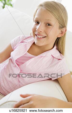 Stock Image - Young Girl Sitting On A Sofa. Fotosearch