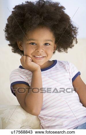 Stock Image - Young Girl Sitting On A Sofa. Fotosearch