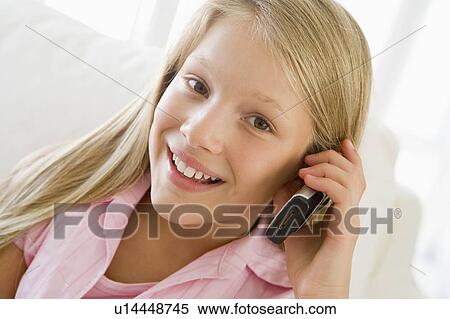 Young Girl Sitting On A Sofa Talking On A Cellphone View Large Photo Image Stock Photography - Young Girl Sitting On A Sofa Talking On A Cellphone. Fotosearch