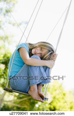 Young girl sitting on swing smiling View Large Photo Image Stock Image - Young girl sitting on swing smiling. Fotosearch