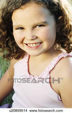 Young girl sitting outdoors smiling View Large Photo Image Picture - Young girl sitting outdoors smiling. Fotosearch